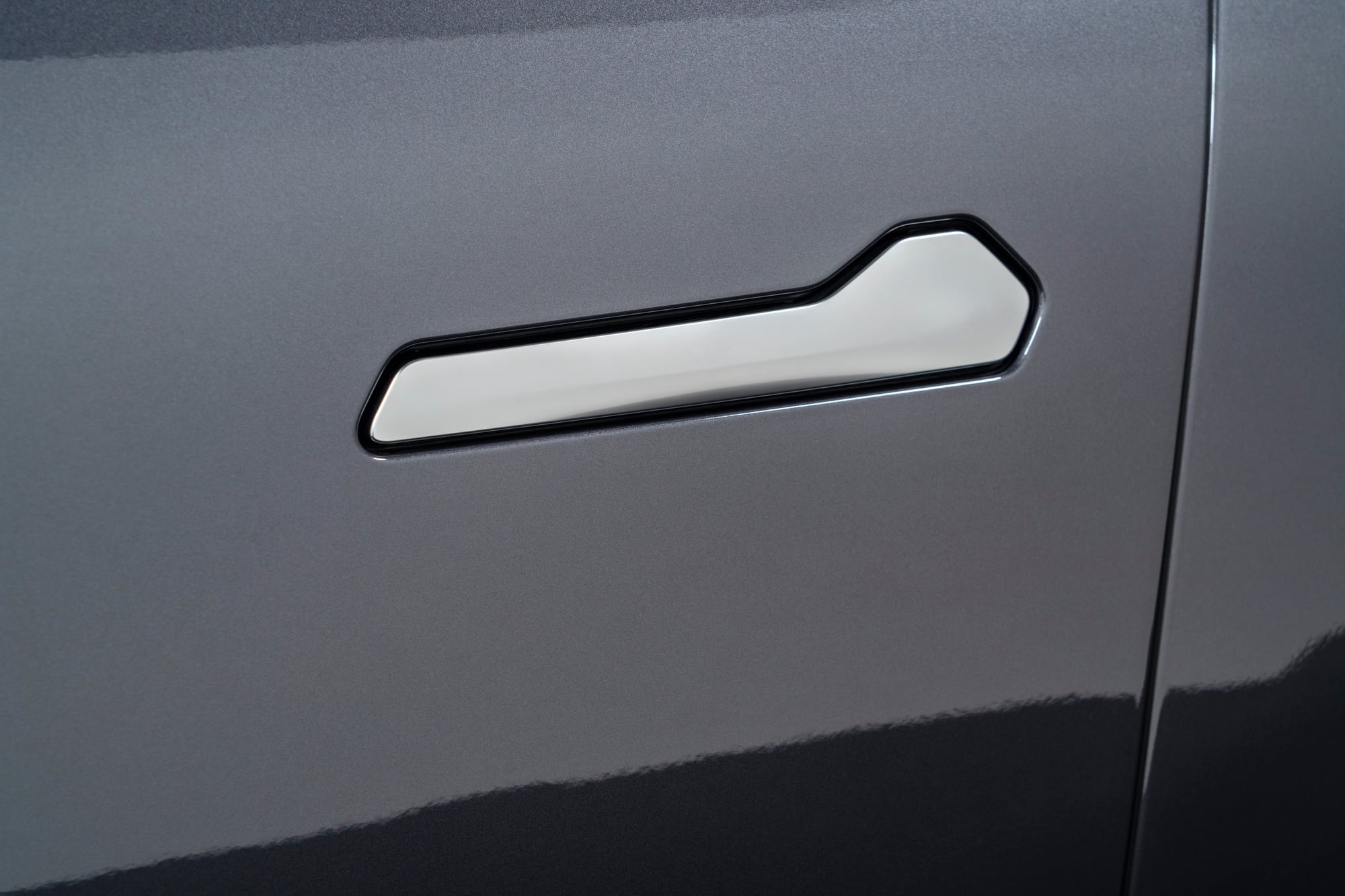 Close-up of a VinFast VF 9 flush door handle on a dark grey door