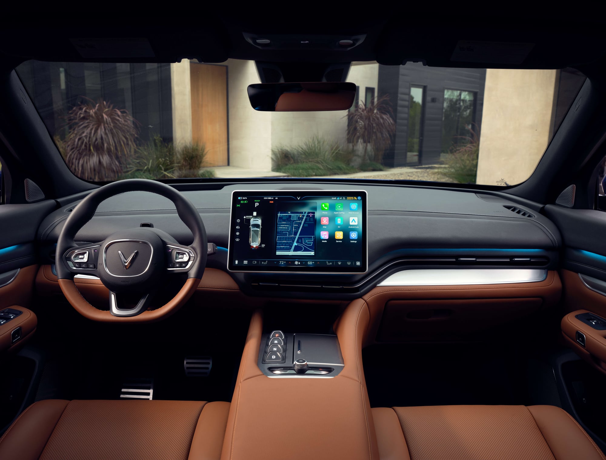 VinFast VF 9 cockpit from the rear seat: steering wheel, 15.6-inch central screen and brown vegan leather